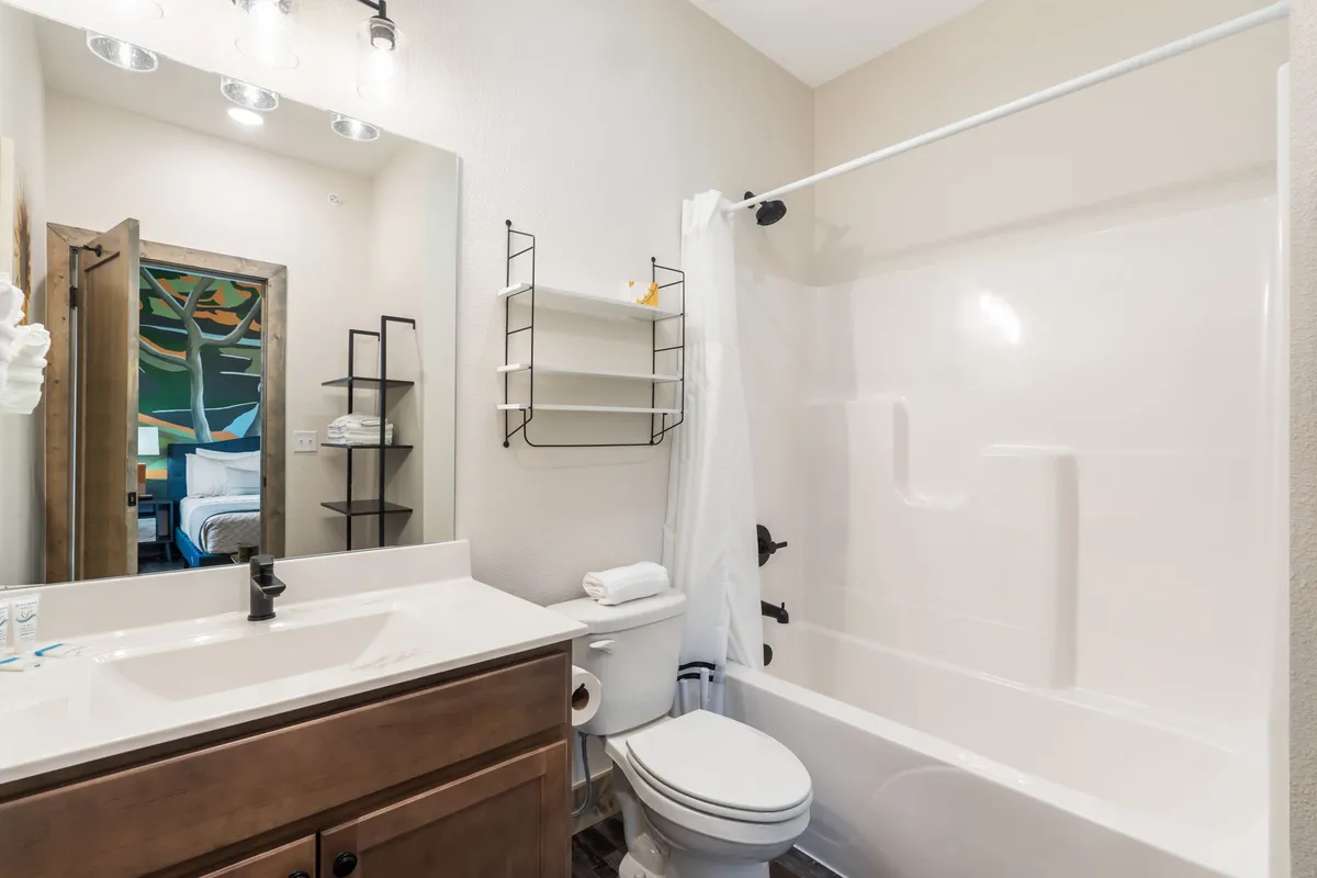 A fresh, modern bathroom with a vanity, mirror, and shower. The space is well-lit and designed for comfort, offering a place to unwind and refresh after a day of adventure.