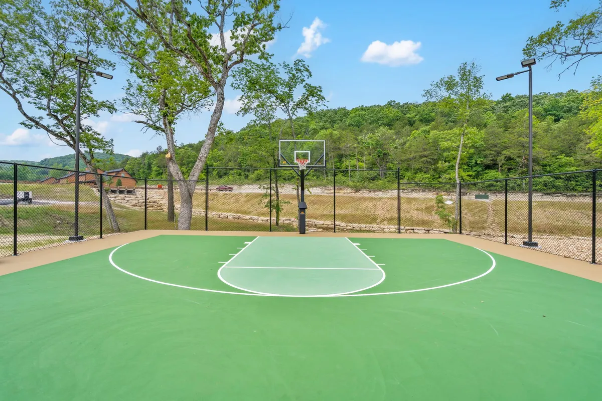 A vibrant basketball court set amidst lush greenery, featuring a basketball hoop and open space for friendly games. The setting invites active recreation and group gatherings, echoing the energetic spirit of the resort’s new sports facilities.
